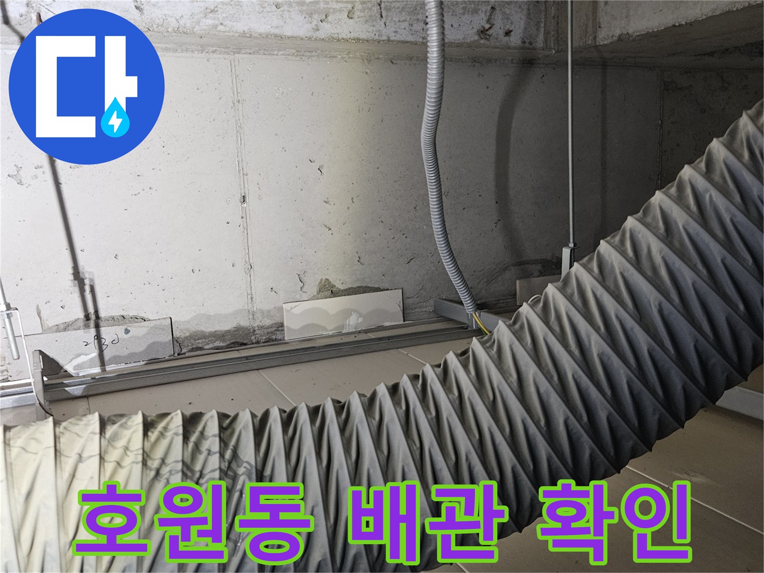 욕실 벽면의 굵은 주름형 호스와 배관 연결부 상세 사진