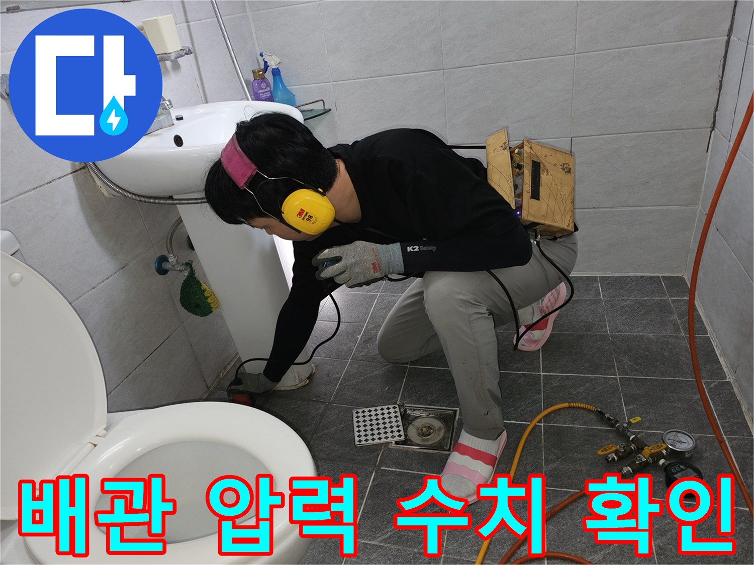 수도 검사-세면대 아래 배관에 연결된 공압 장비와 게이지