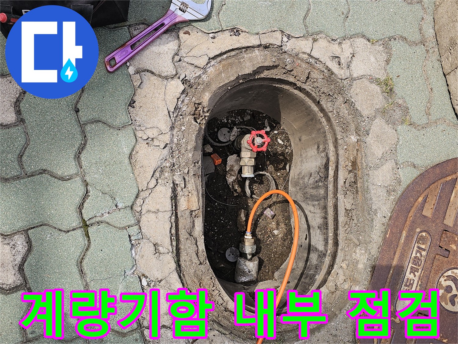 수도 계량기 밸브와 검사용 호스가 놓인 외부 바닥 현장