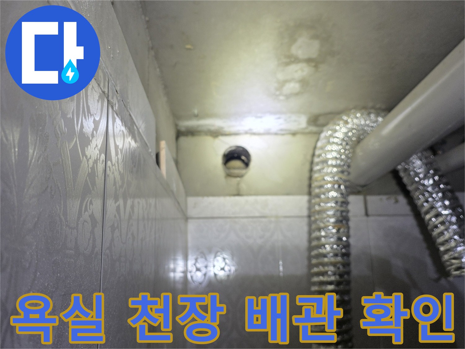 화장실 벽면과 천장-배관 연결 부위의 근접 사진입니다.