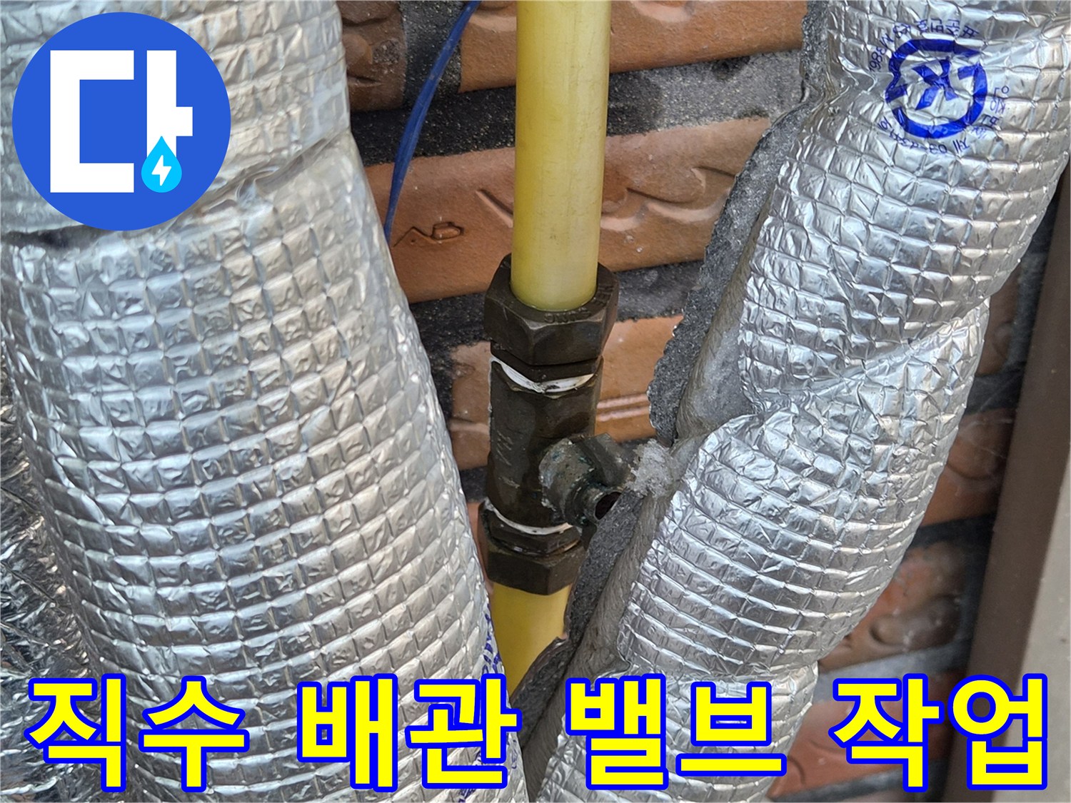 은박 단열재로 감싸진 노란색 배관의 새로운 중간 밸브 설치 모습