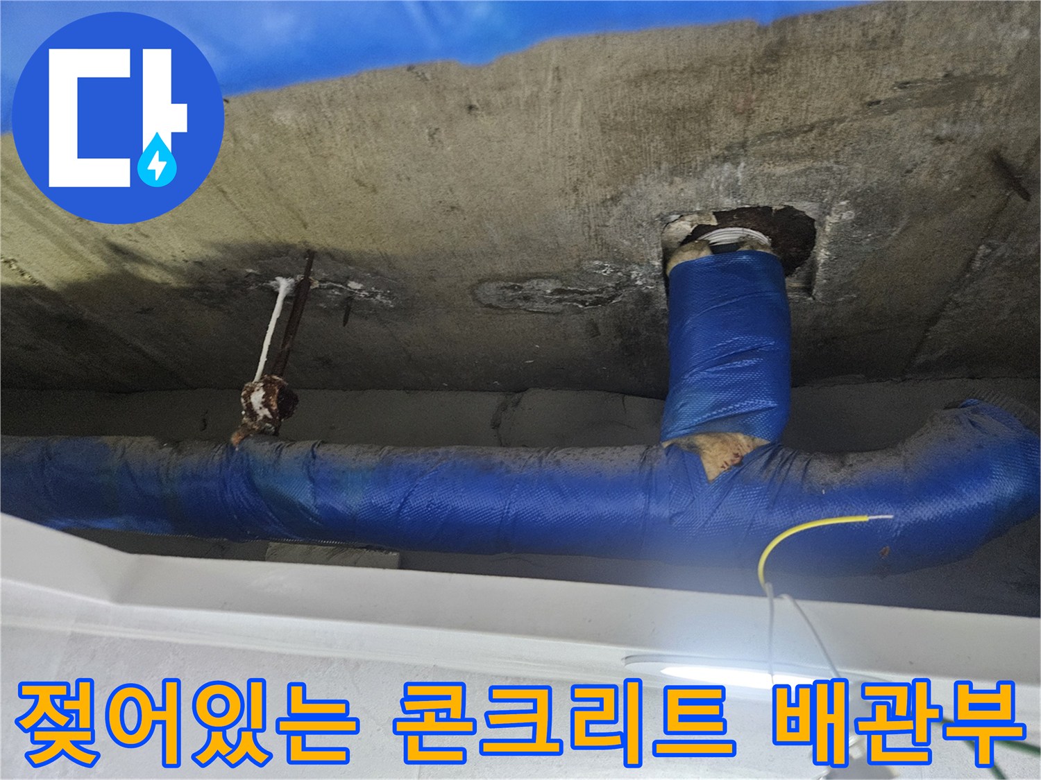 파란색 보온재로 마감된 천장 배관과 젖은 슬래브