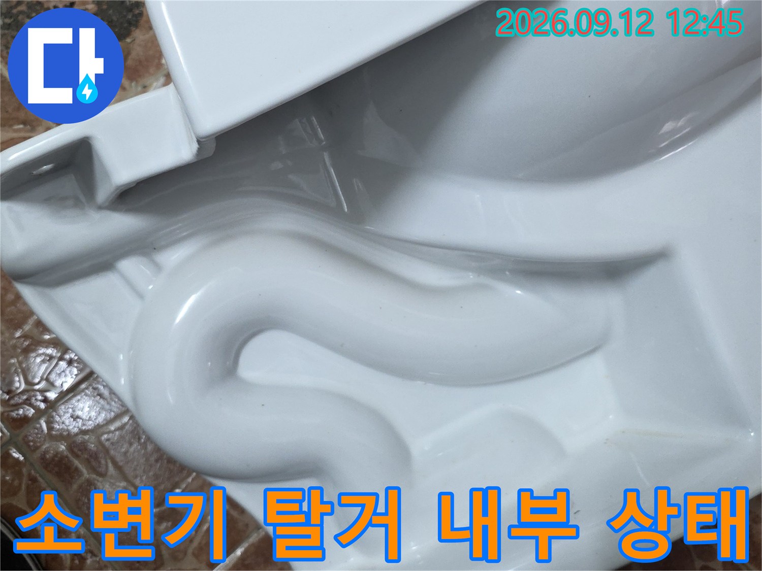 소변기를 제거한 후 드러난 하단 배관과 타일 주변 모습