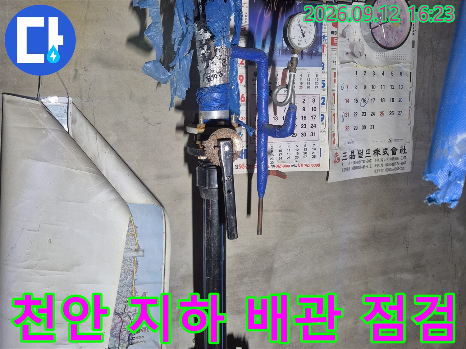 천안 서북구 아파트 지하 공간의 파란색 보온재로 감싸진 급수 배관과 계량기 모습