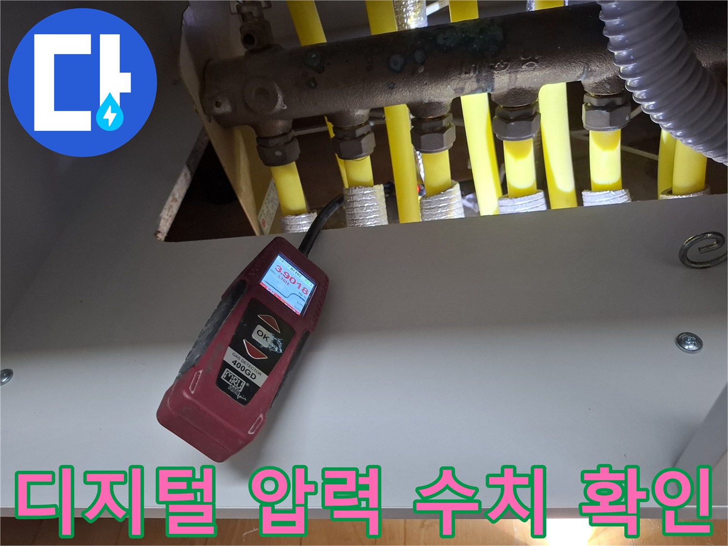 분배기 라인에 연결된 측정 장비의 수치를 정밀하게 관찰하는 장면입니다.
