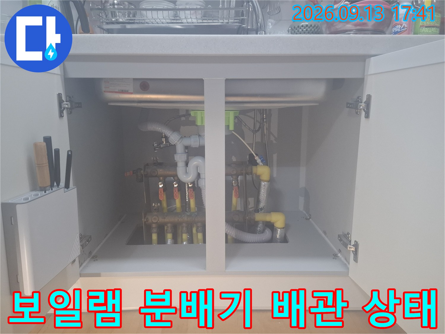 싱크대 하단부에 위치한 보일러 분배기와 노란색 PE-RT 배관의 연결 부위입니다.