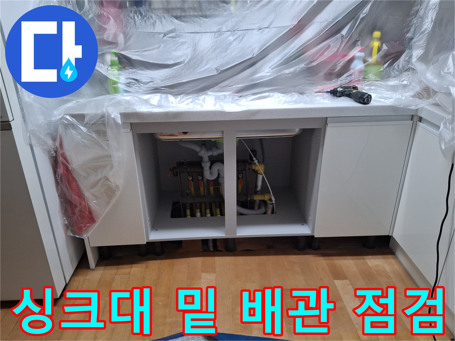싱크대 하부장 내부의 난방 분배기 및 밸브 노출 상태