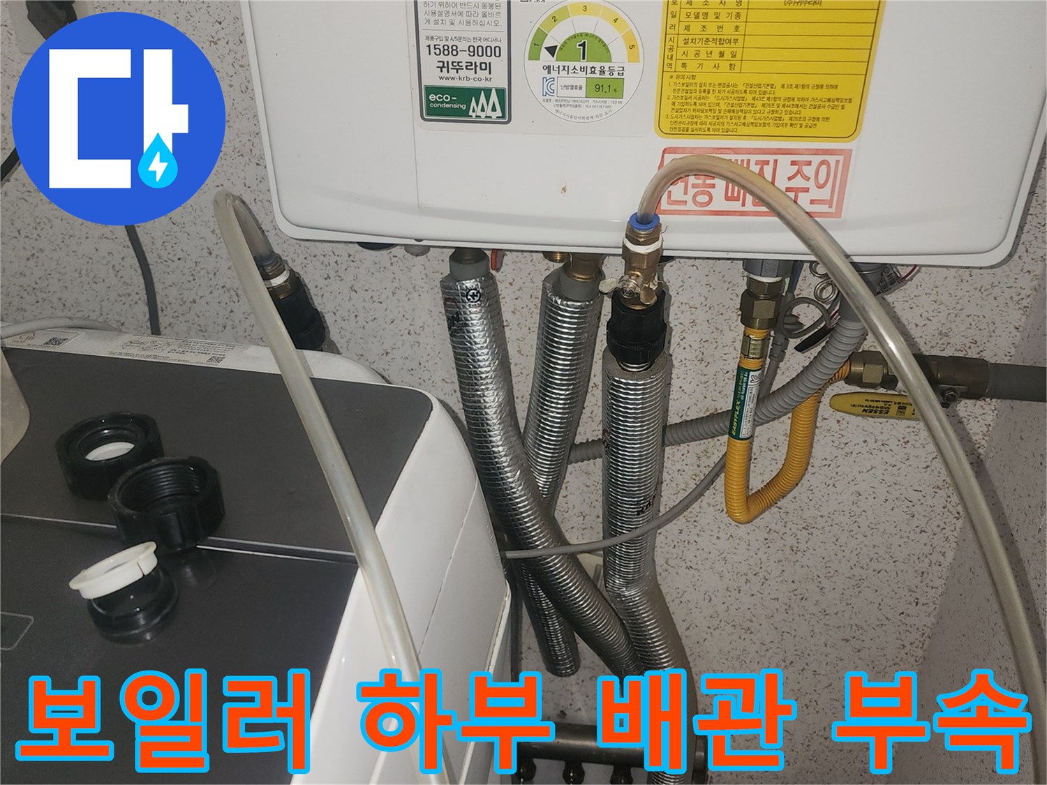 보일러 밑에 연결된 은색 주름관과 노란색 밸브 배관