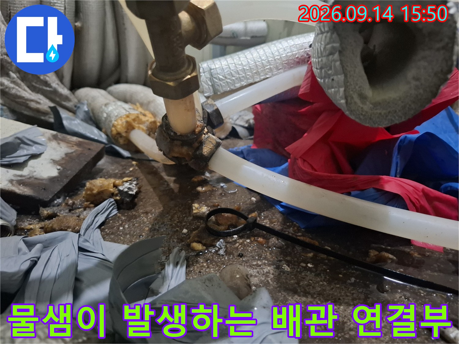 투명 호스와 금속 밸브 사이의 누수 지점을 근접 촬영한 사진입니다.