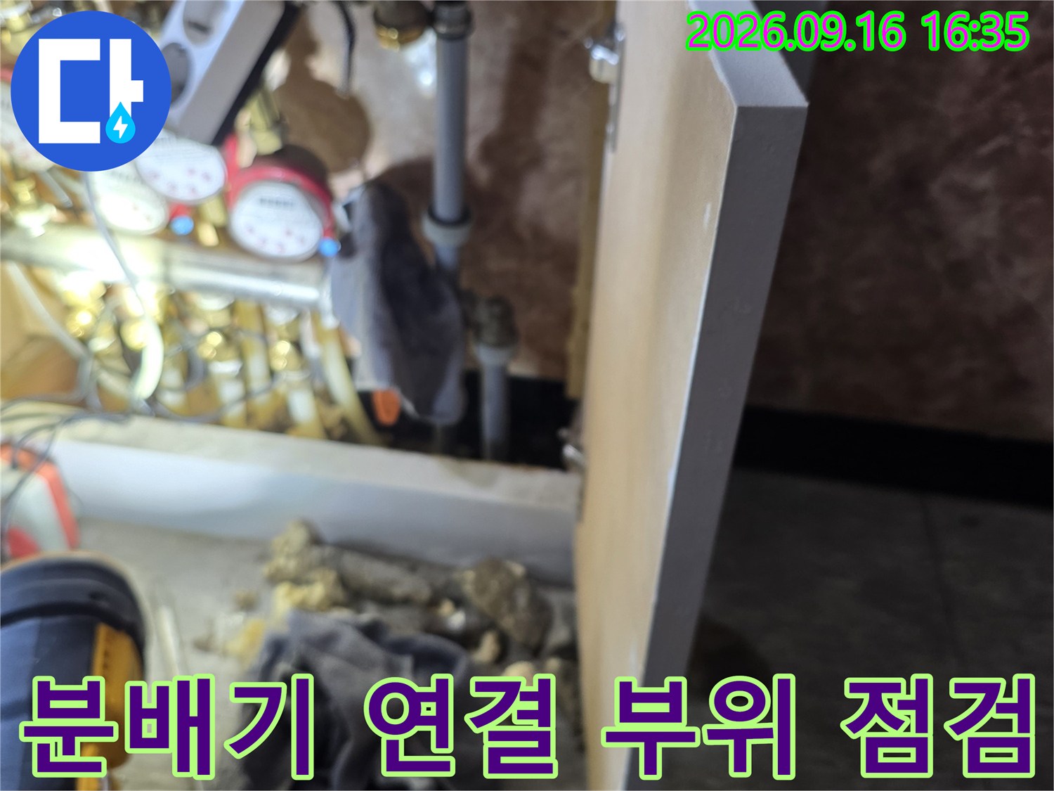 난방 분배기 주변의 복잡한 배관과 압력 측정 장비 모습