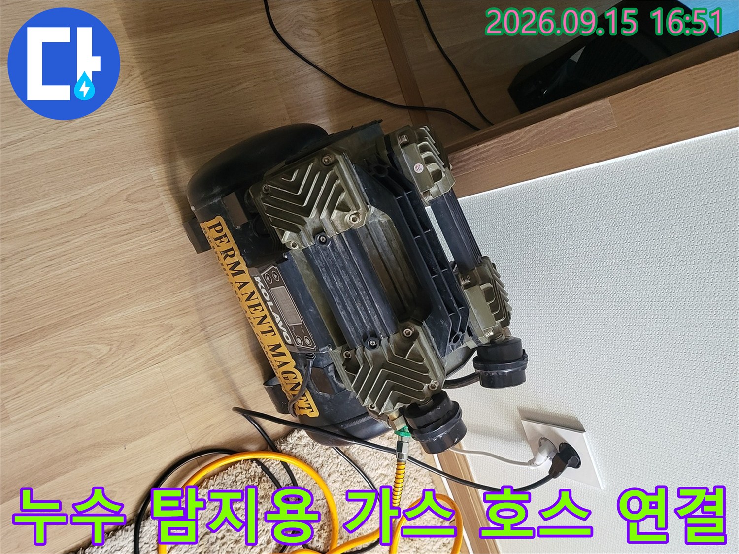 전기 콘센트에 연결된 컴프레셔와 누수 지점 확인을 위한 노란색 가스 호스