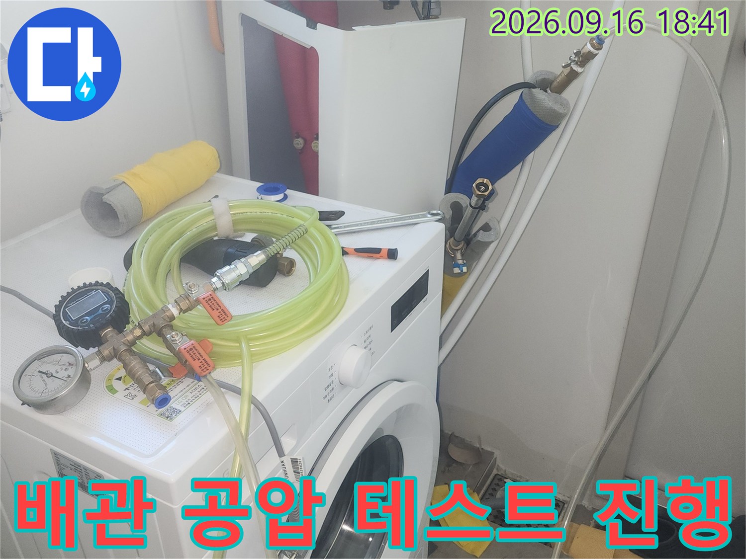 세탁실 수도 연결 부위에 설치된 압력 측정 장비와 호스 모습입니다.