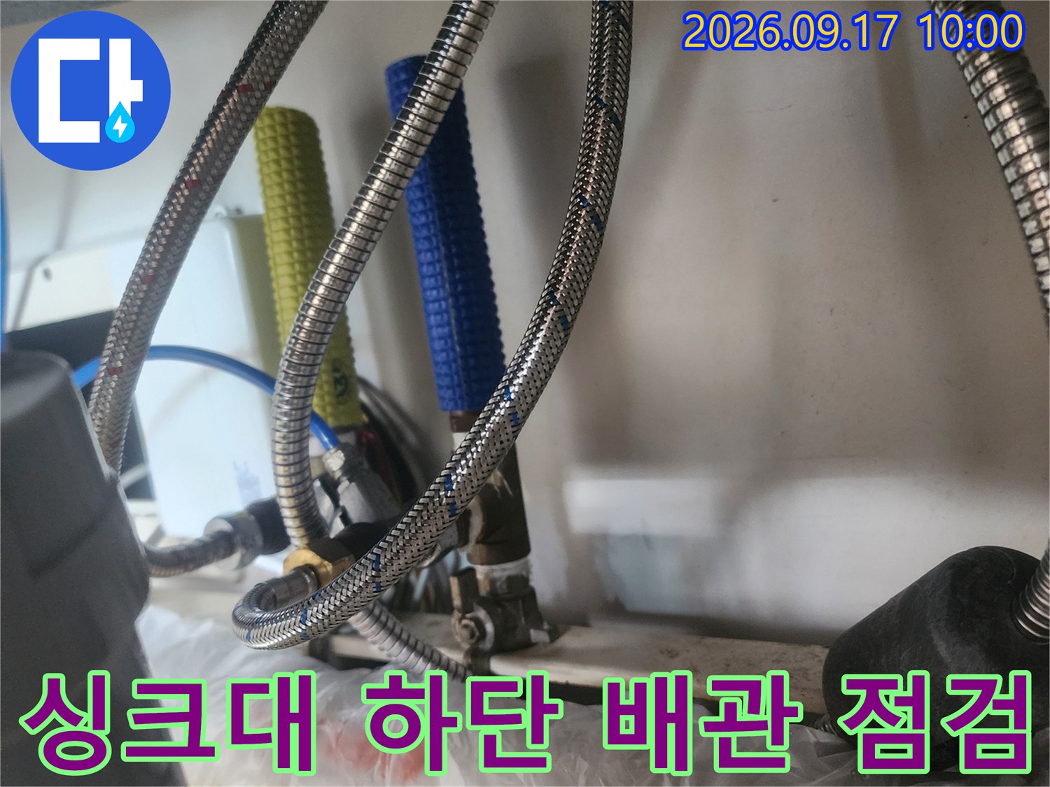 군포시 부곡동 싱크대 하부장 내부의 금속 자재와 배관 연결 상태를 확인하는 모습입니다.