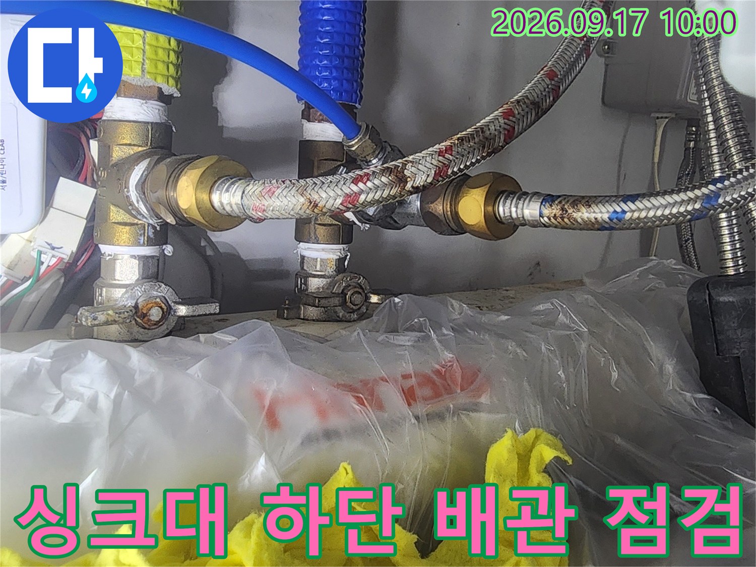 싱크대 아래쪽 수도 밸브와 금속 호스의 연결 부위를 촬영했습니다.
