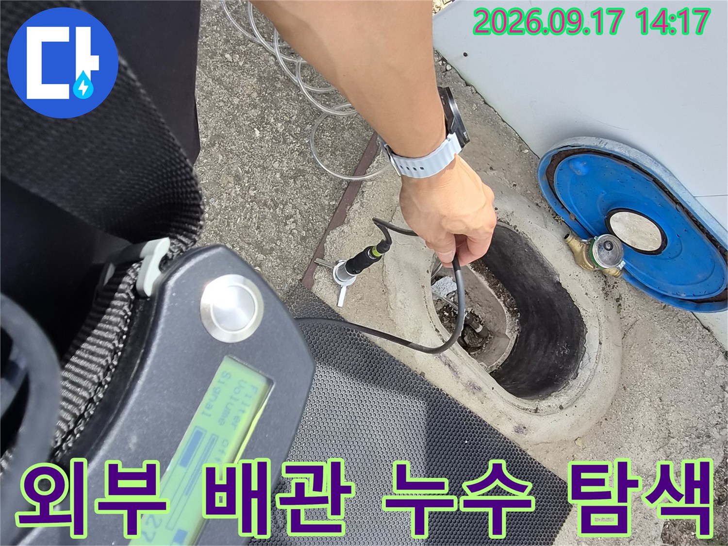 야외 계량기 함 부근에서 청음기를 사용하여 배관의 누수를 찾는 모습입니다.