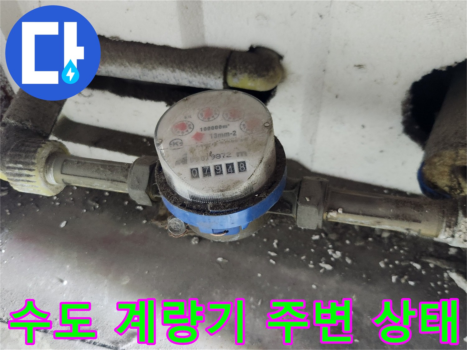 먼지가 쌓인 수도 계량기와 연결 배관의 모습입니다.